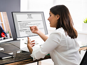 Frau am Schreibtisch vor Laptop